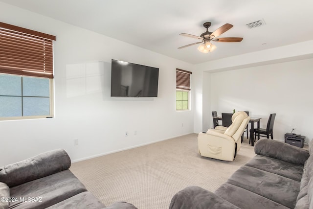 carpeted living room with ceiling fan