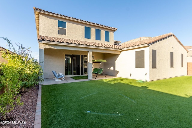 back of property with a patio area and a yard