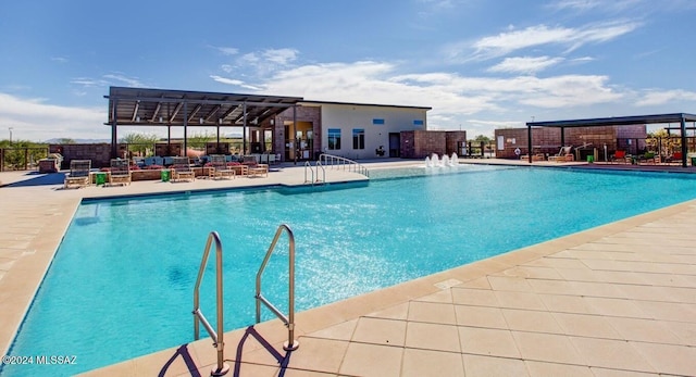 view of swimming pool with pool water feature and a patio