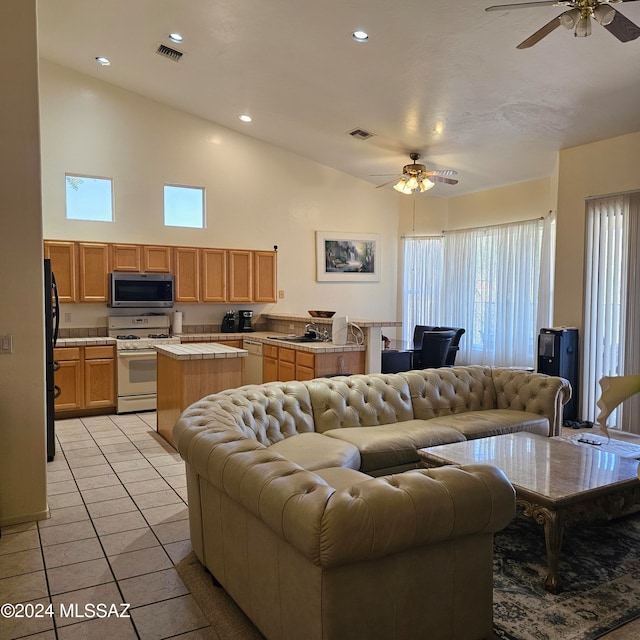 living room with sink, high vaulted ceiling, light tile patterned floors, and ceiling fan