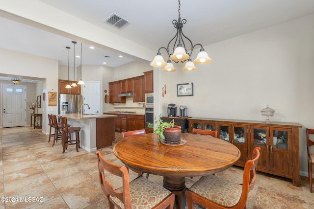 dining area with sink and an inviting chandelier