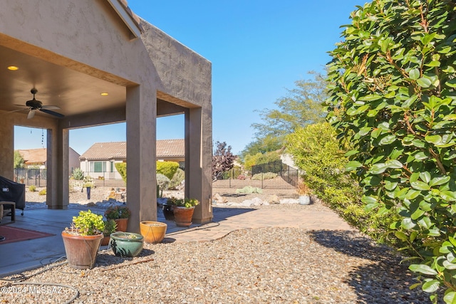 view of yard with ceiling fan and a patio area