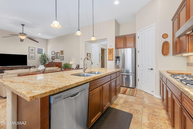 kitchen featuring ceiling fan, sink, hanging light fixtures, a center island with sink, and appliances with stainless steel finishes