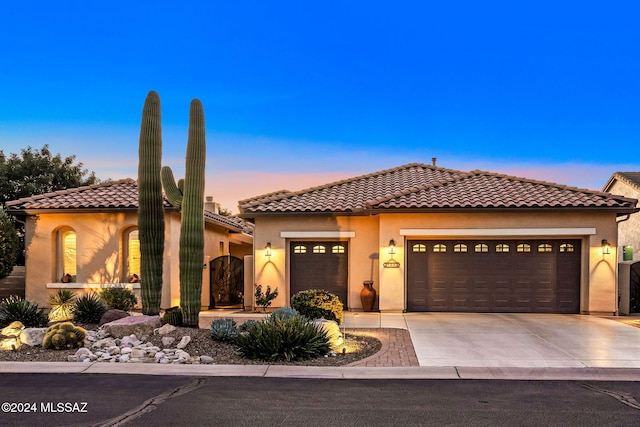 mediterranean / spanish-style house with a garage