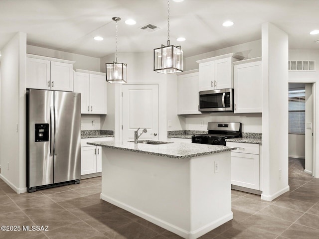 kitchen featuring a sink, stainless steel appliances, visible vents, white cabinets, and an island with sink