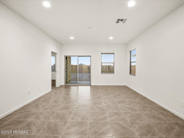 empty room with visible vents, recessed lighting, and baseboards