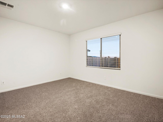 carpeted empty room featuring baseboards and visible vents
