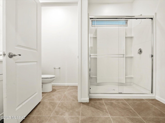 full bathroom featuring toilet, a stall shower, tile patterned flooring, and baseboards