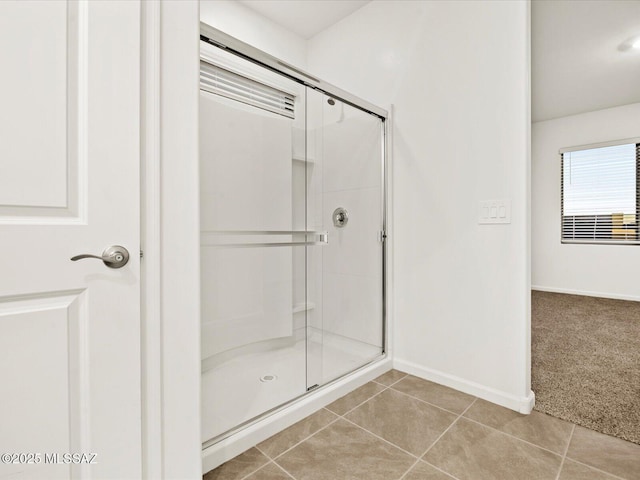 bathroom featuring tile patterned floors, baseboards, and a shower stall