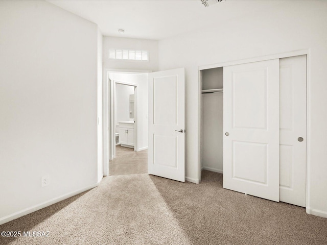 unfurnished bedroom featuring baseboards, carpet floors, and a closet