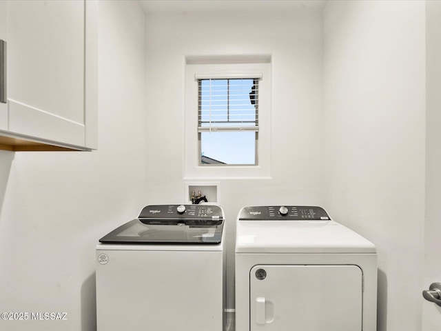 washroom featuring washer and clothes dryer and cabinet space