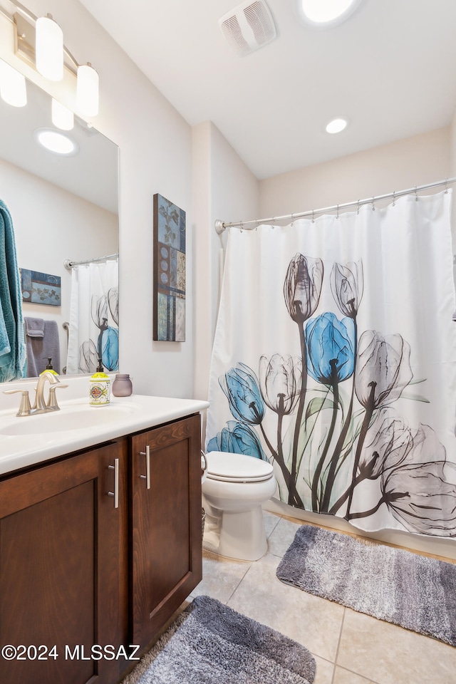 bathroom with toilet, vanity, and tile patterned floors