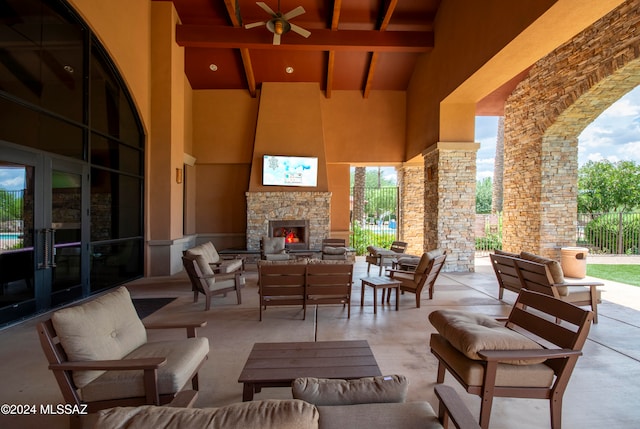 view of patio / terrace featuring an outdoor living space with a fireplace, ceiling fan, and french doors