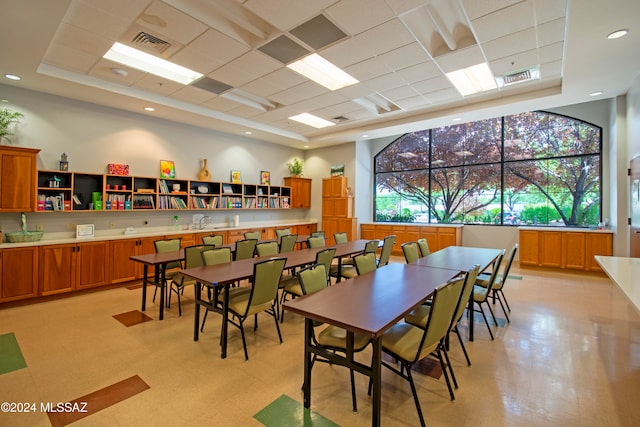 dining space featuring a raised ceiling and a drop ceiling