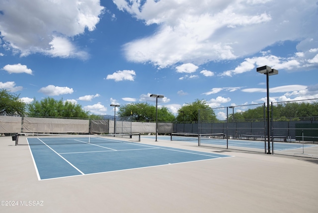 view of tennis court with basketball hoop