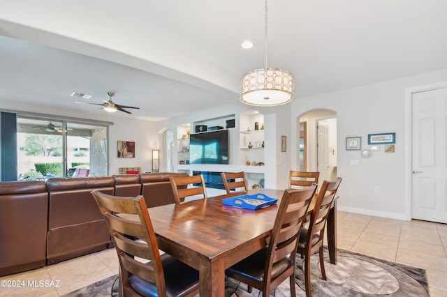 tiled dining space featuring built in shelves and ceiling fan