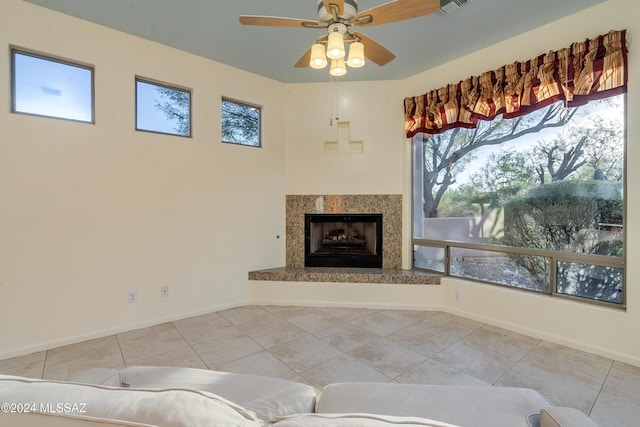 tiled living room with ceiling fan and a fireplace