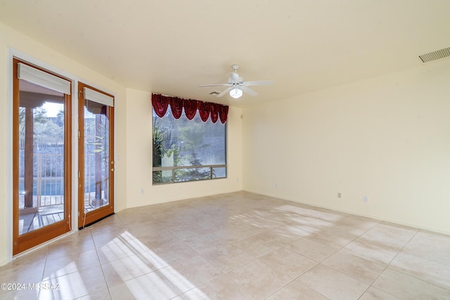 spare room featuring plenty of natural light, ceiling fan, and light tile patterned floors