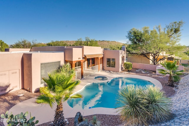 view of swimming pool featuring an in ground hot tub and a patio