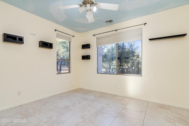 tiled empty room featuring ceiling fan