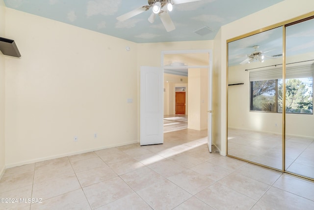 unfurnished bedroom with light tile patterned flooring, a closet, and ceiling fan