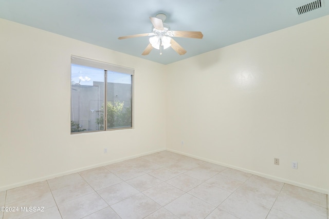 tiled spare room with ceiling fan