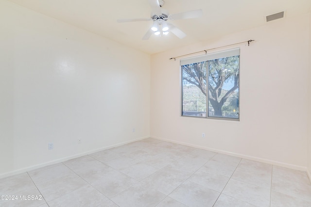 tiled empty room featuring ceiling fan