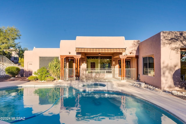 view of swimming pool featuring an in ground hot tub