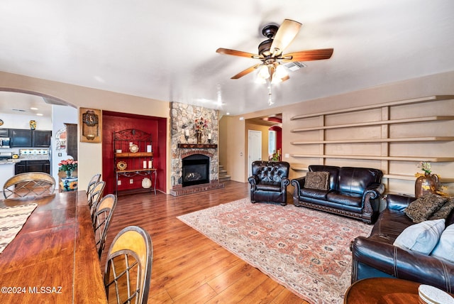 living room with ceiling fan, a fireplace, and hardwood / wood-style floors