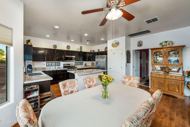 dining space with ceiling fan, sink, and dark hardwood / wood-style floors