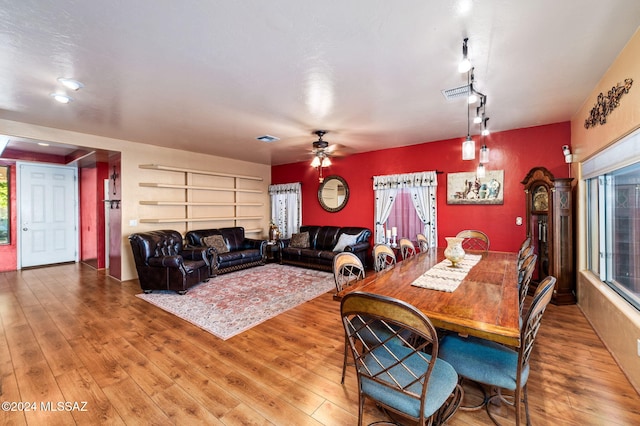 dining area with hardwood / wood-style floors, track lighting, and ceiling fan