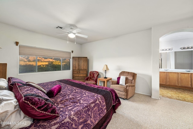 carpeted bedroom featuring connected bathroom and ceiling fan