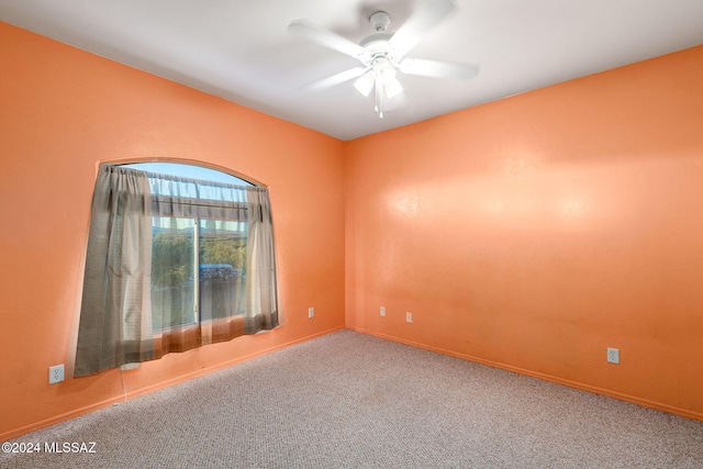 carpeted spare room featuring ceiling fan