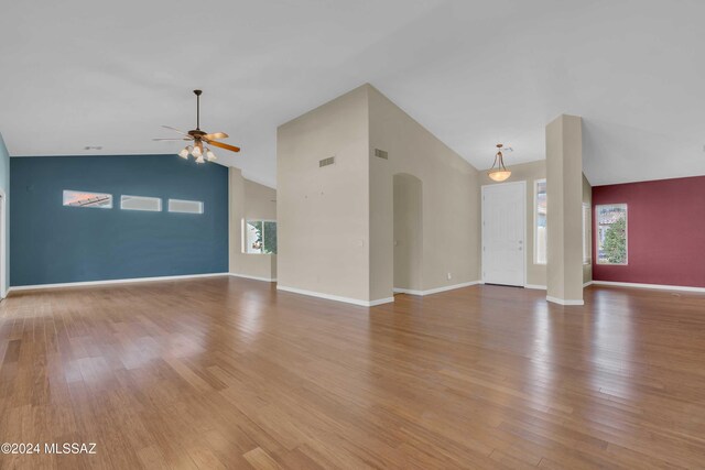 unfurnished living room featuring vaulted ceiling, hardwood / wood-style flooring, and ceiling fan