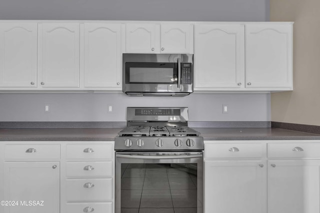 kitchen featuring tile patterned floors, appliances with stainless steel finishes, and white cabinets