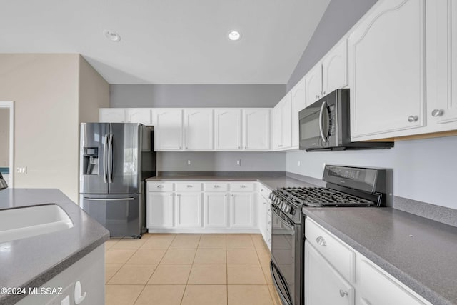 kitchen with sink, appliances with stainless steel finishes, light tile patterned floors, and white cabinets