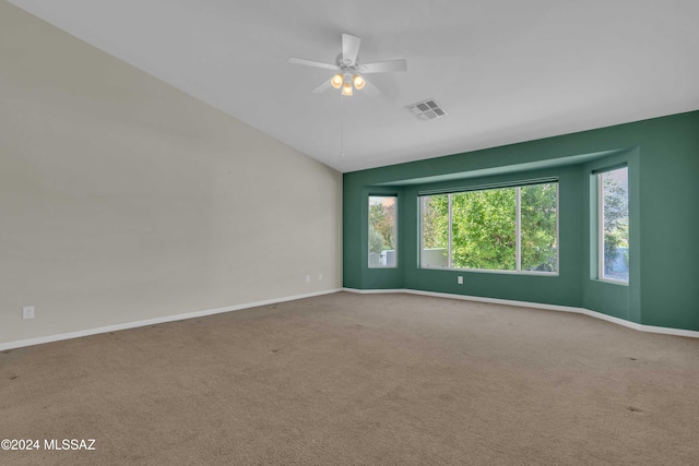 empty room with lofted ceiling, carpet floors, and ceiling fan