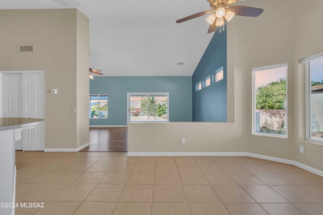 tiled spare room with high vaulted ceiling and ceiling fan