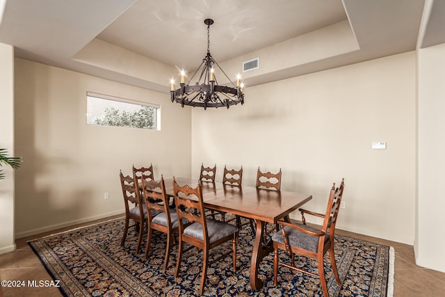 tiled dining space with a notable chandelier and a tray ceiling