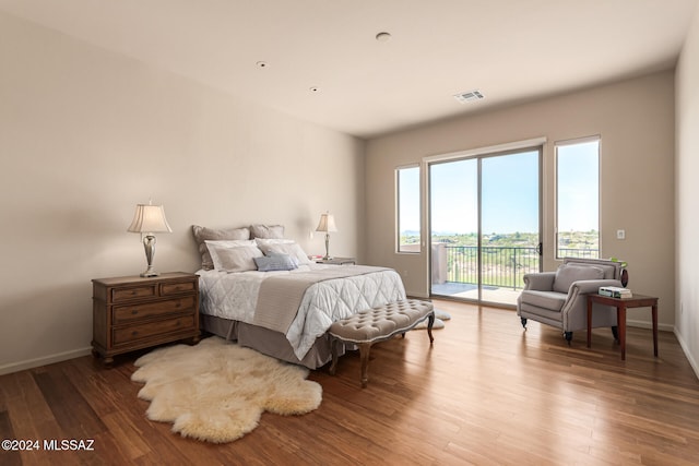 bedroom with hardwood / wood-style floors and access to outside