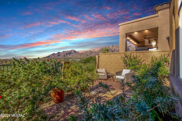 yard at dusk featuring an outdoor living space and a mountain view