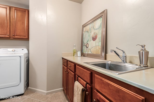 clothes washing area with sink, light tile patterned floors, washer / clothes dryer, and cabinets