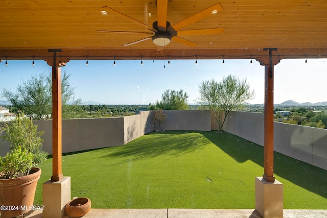 view of yard featuring a mountain view and ceiling fan