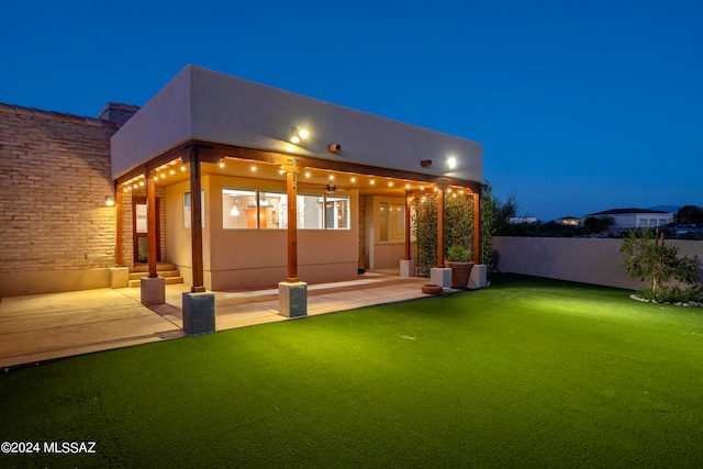 rear view of property featuring a yard and a patio