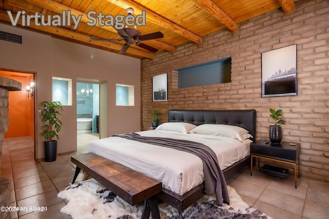 tiled bedroom featuring connected bathroom, beamed ceiling, wooden ceiling, brick wall, and ceiling fan