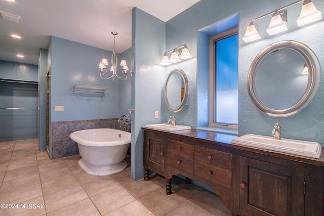 bathroom featuring vanity, a chandelier, tile patterned floors, and a bath