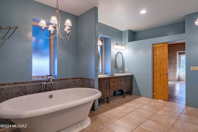 bathroom featuring vanity, a tub, tile patterned floors, and a chandelier