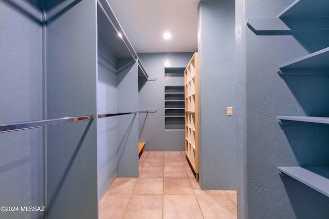 walk in closet with light tile patterned floors