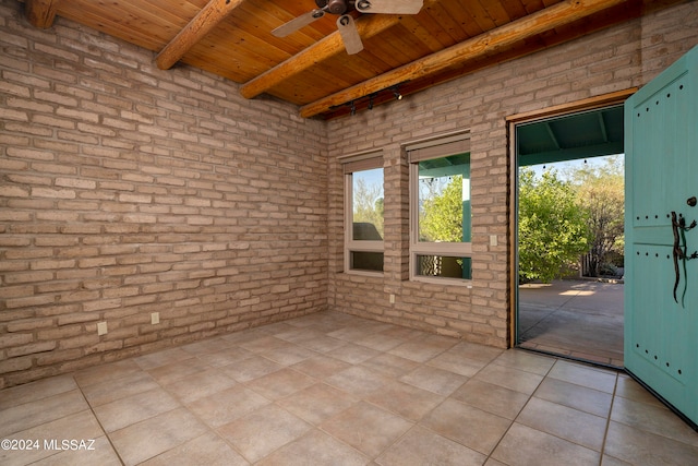 unfurnished sunroom featuring wood ceiling, beam ceiling, and ceiling fan