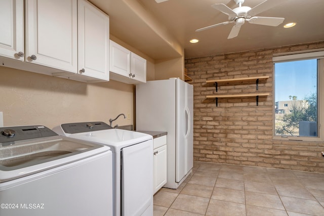 washroom with washer and dryer, light tile patterned floors, ceiling fan, brick wall, and cabinets